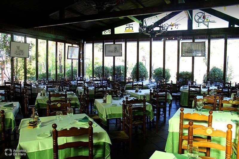 Un restaurante con mesas y sillas y muchas ventanas.