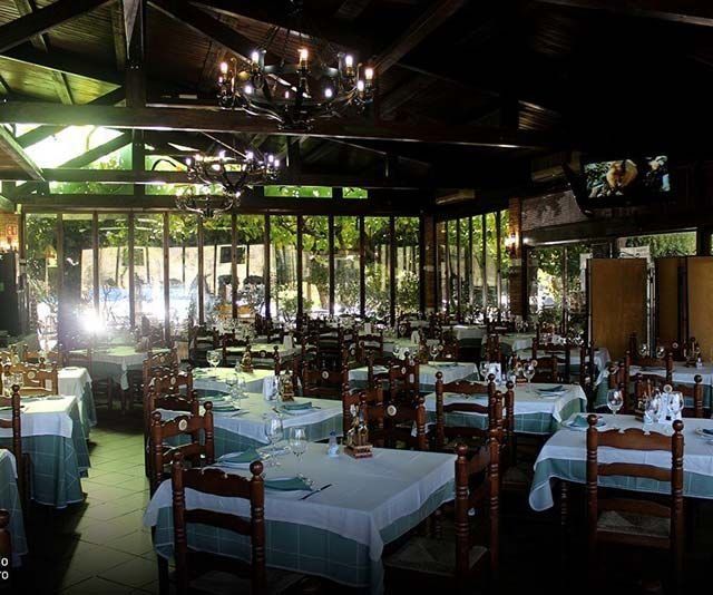 Un restaurante con mesas y sillas y una lámpara de araña colgando del techo.