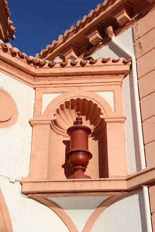 Un edificio con un jarrón rojo encima.