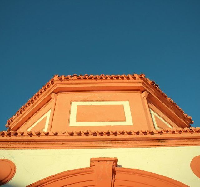 Un edificio naranja con un cielo azul al fondo.