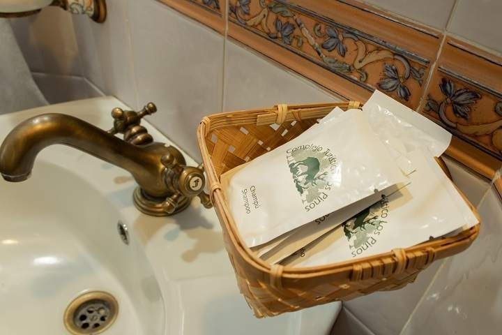 Un lavabo de baño con una cesta de artículos de tocador al lado.
