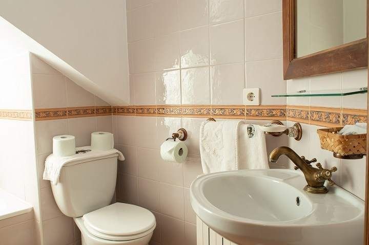 Un baño con inodoro, lavabo y espejo.