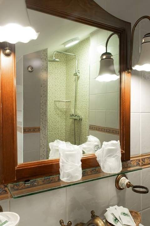 Un baño con un espejo y un estante con toallas encima.