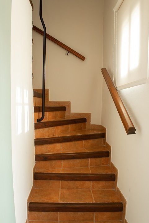 Un conjunto de escaleras con escalones de madera y barandilla de madera.