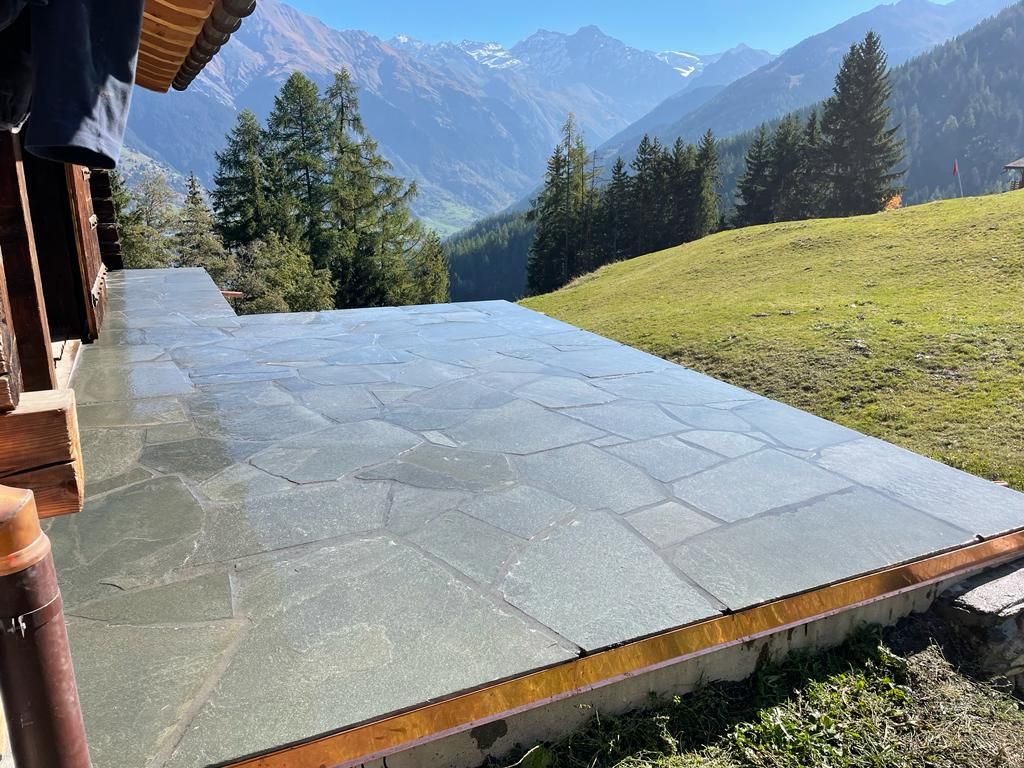 Un maçon utilise une truelle pour appliquer du mortier sur un mur de briques, en portant des gants.