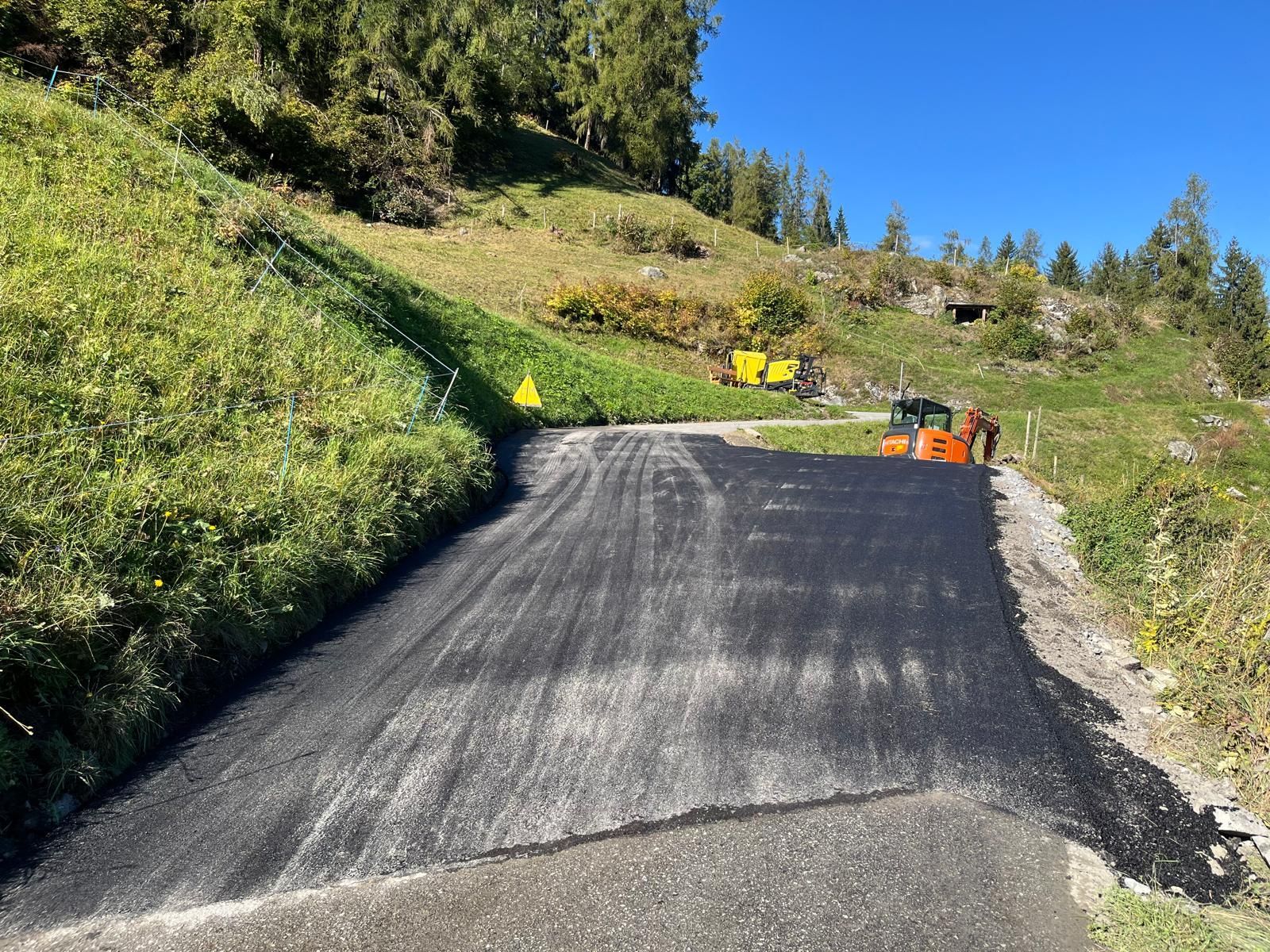 Un maçon construit un mur en briques rouges et mortier sur un chantier.