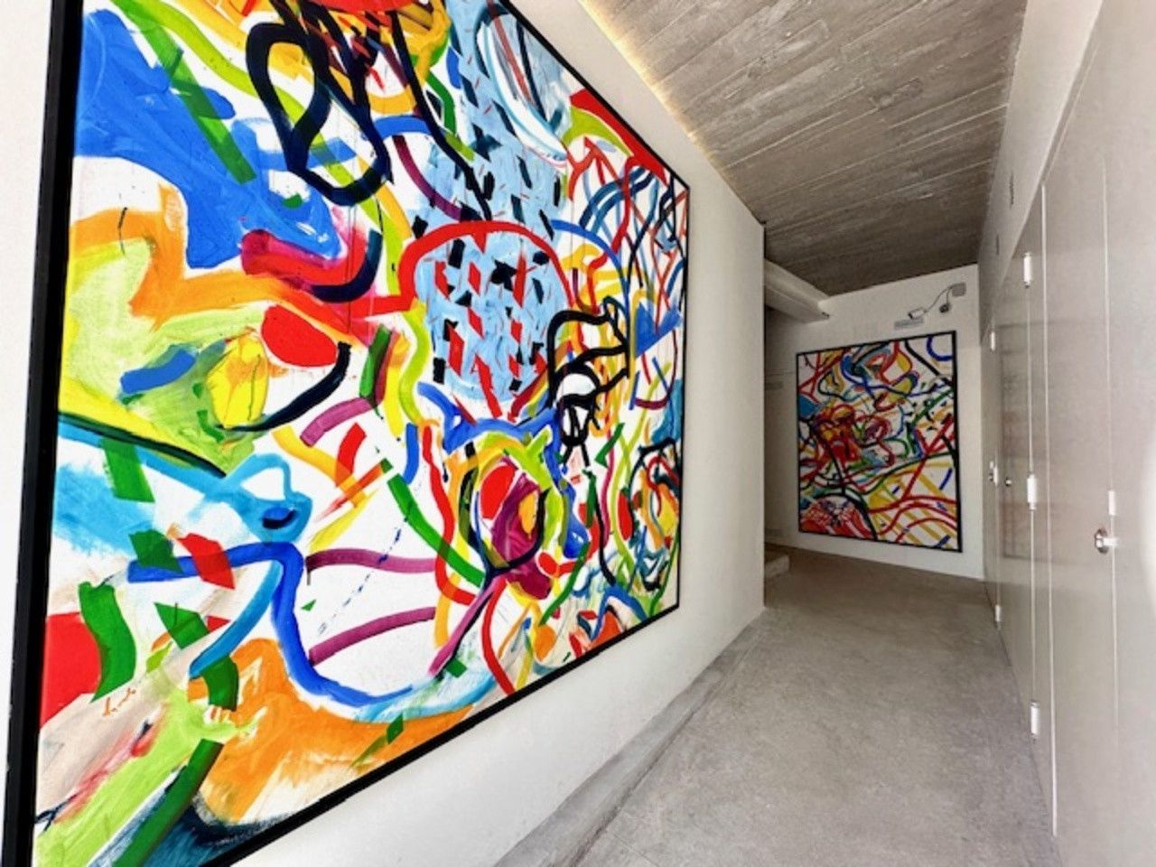 Un pasillo con una gran pintura colorida en la pared.