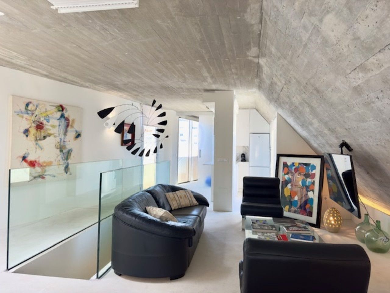 Una sala de estar con un sofá y sillas y un reloj en la pared.