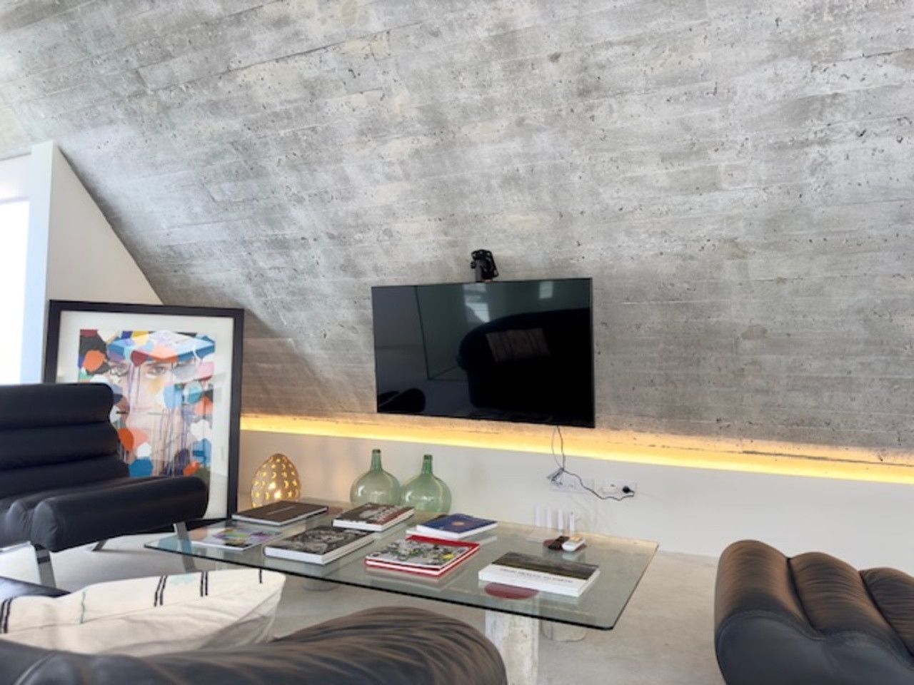 Una sala de estar con un televisor de pantalla plana en la pared.