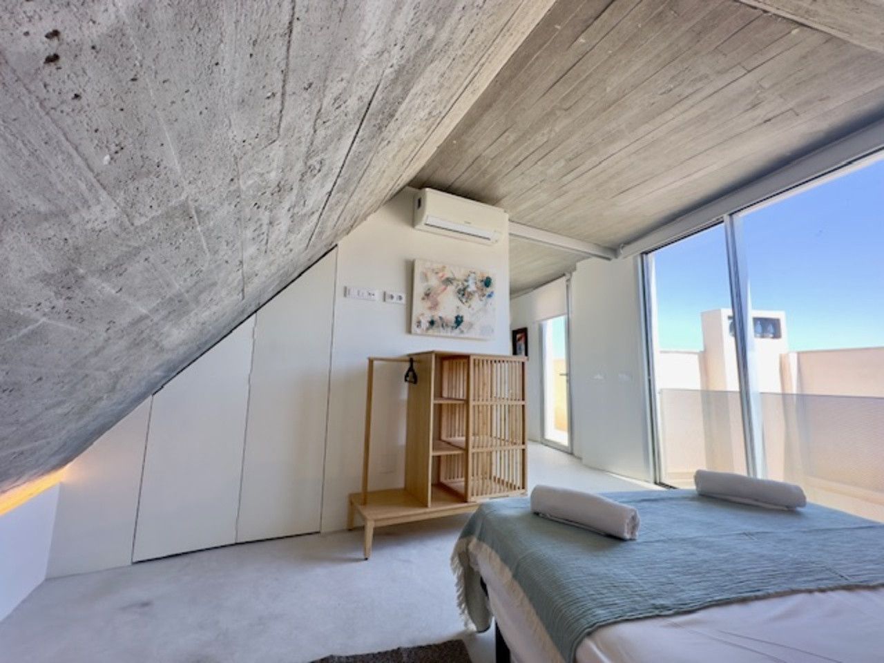 Un dormitorio con una cama y una ventana grande.