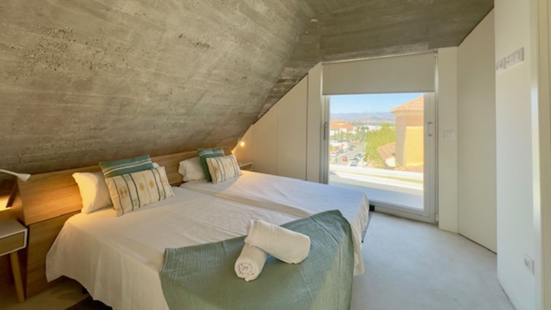 Un dormitorio con dos camas y una gran ventana.