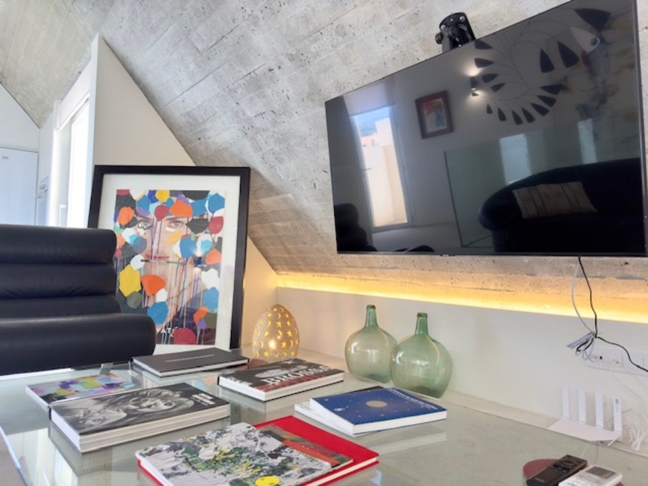 Una sala de estar con un televisor de pantalla plana grande en la pared.