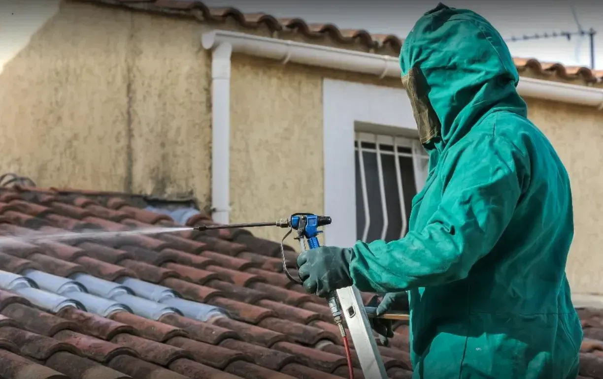 Gros plan sur un homme en combinaison traitant une toiture