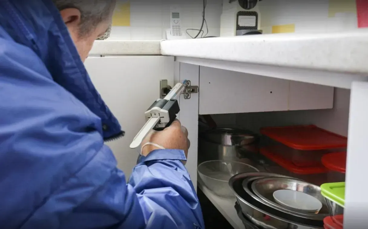 Gros plan sur un homme traitant un placard contre les cafards