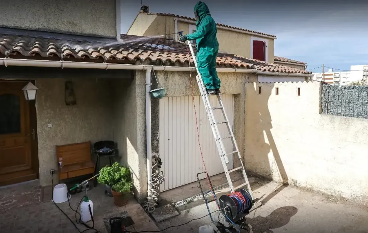 Homme en combinaison traitant une toiture