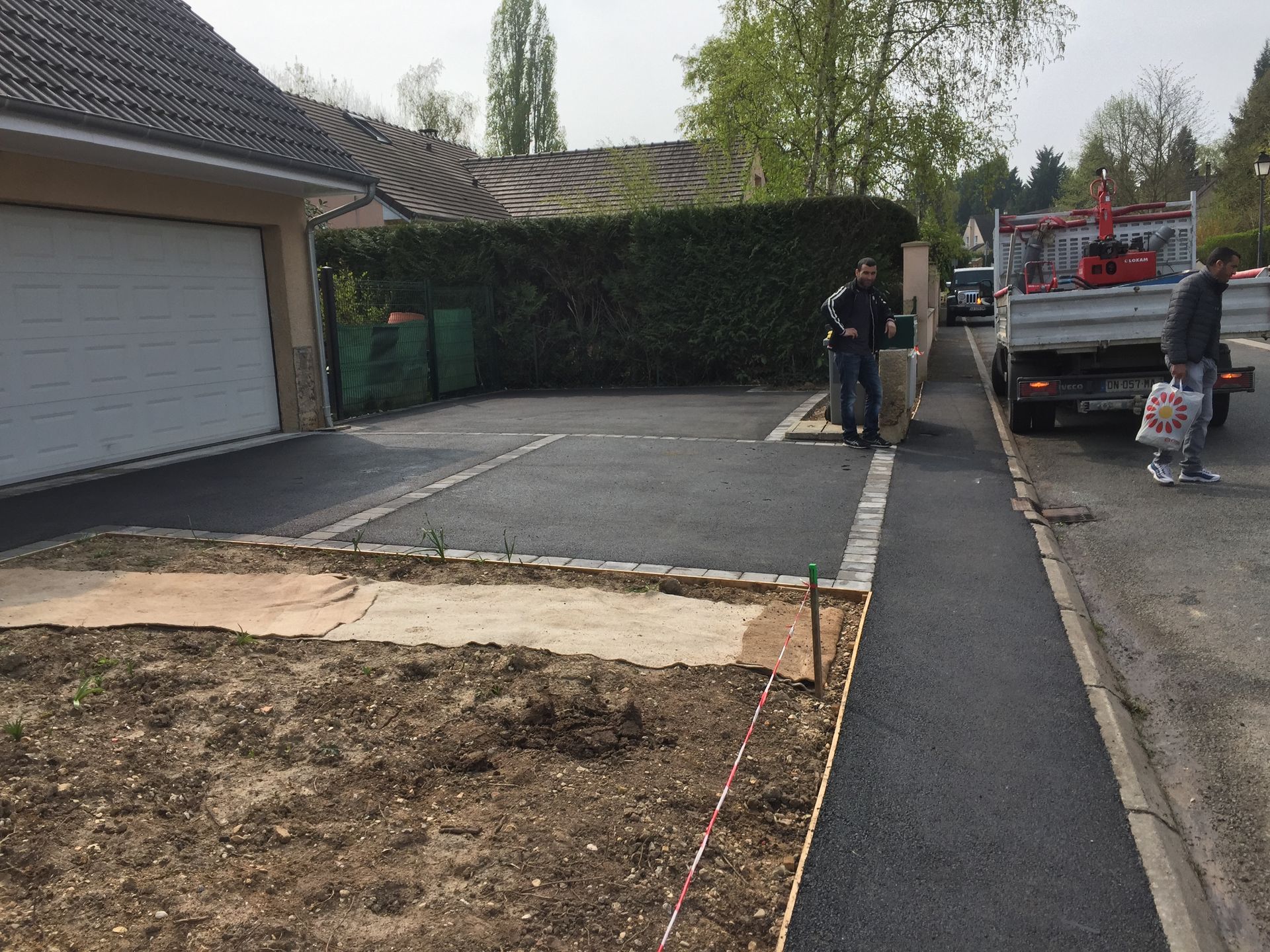 Coulage d'un enrobé pour une allée carrossable devant une entrée de garage