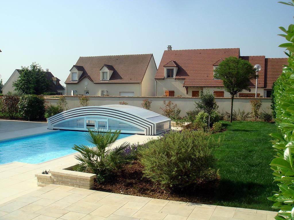 Jardin aménagé avec piscine, dallage et massif de plantes