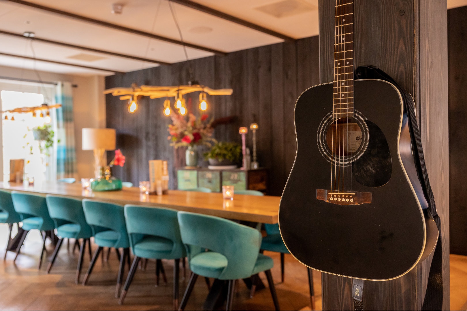 Stamtafel met 14 stoelen. gitaar aan de wand. 