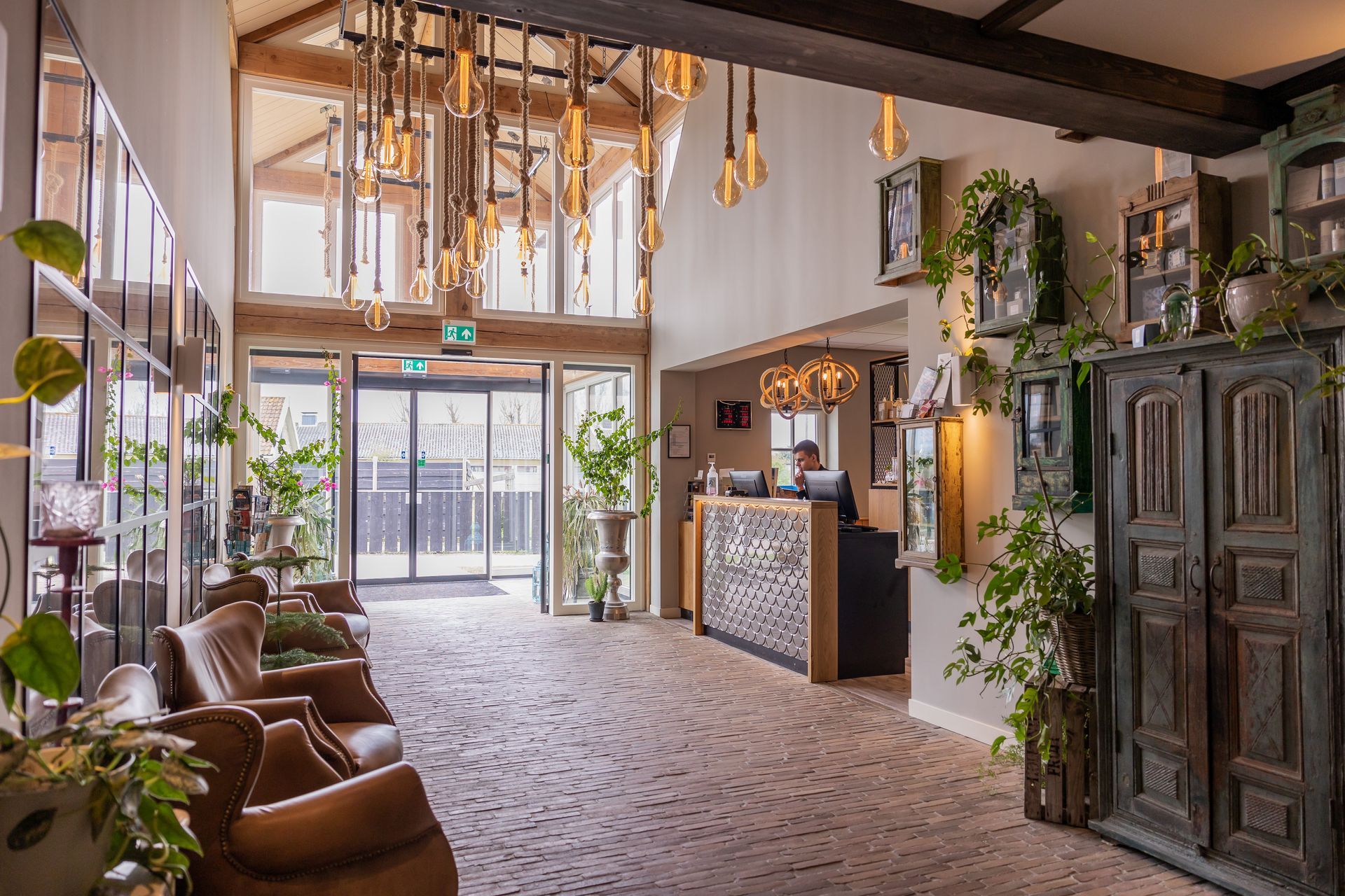 A lobby of a hotel with a reception desk and chairs.