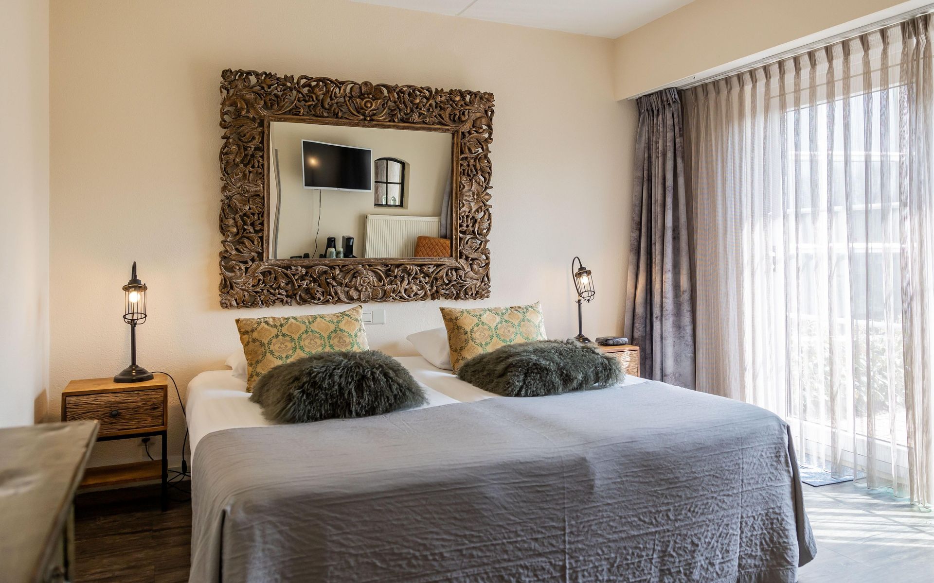 There is a large mirror above the bed in the bedroom.