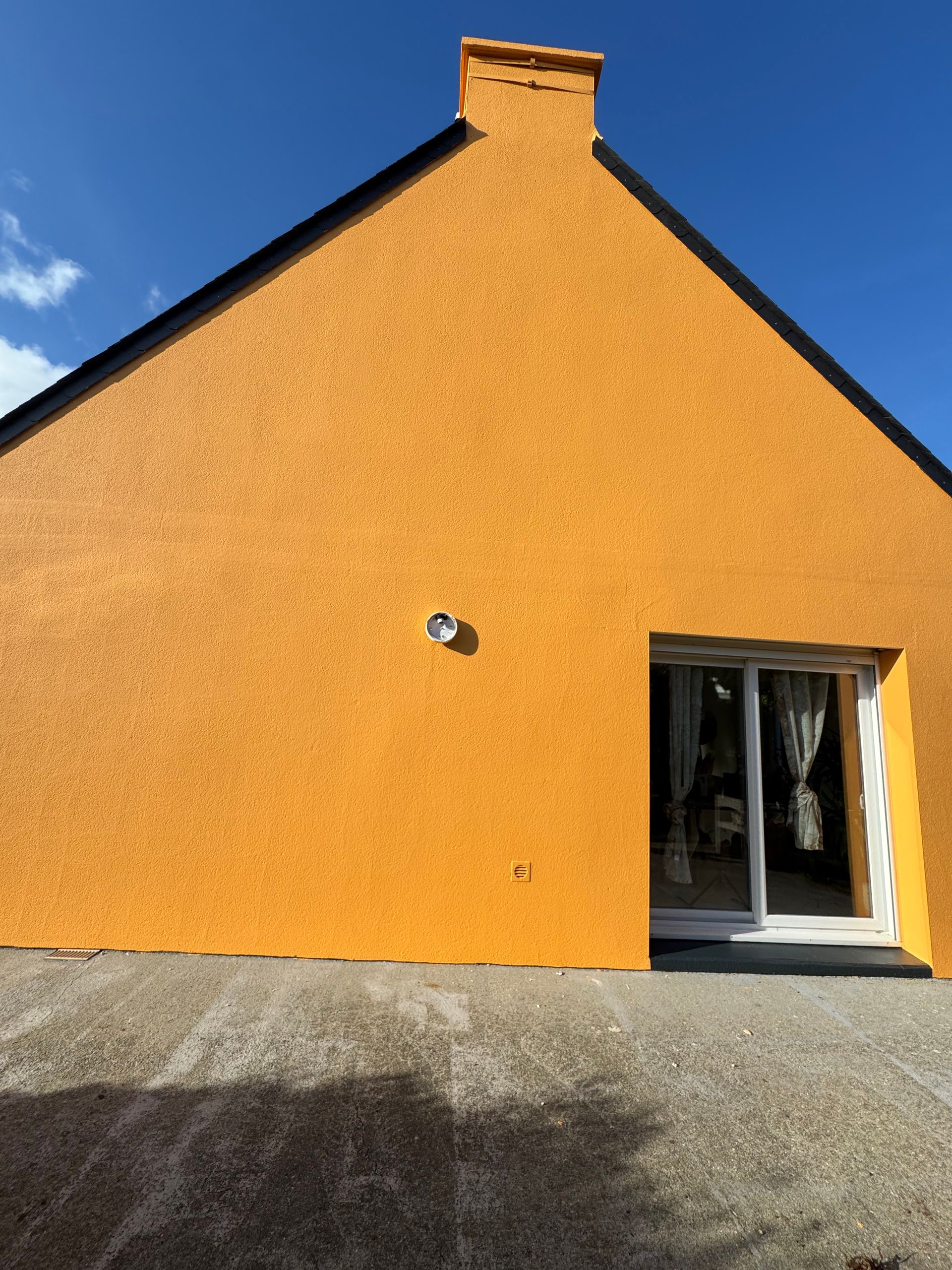 Mur d'une maison orange avec une cheminée.