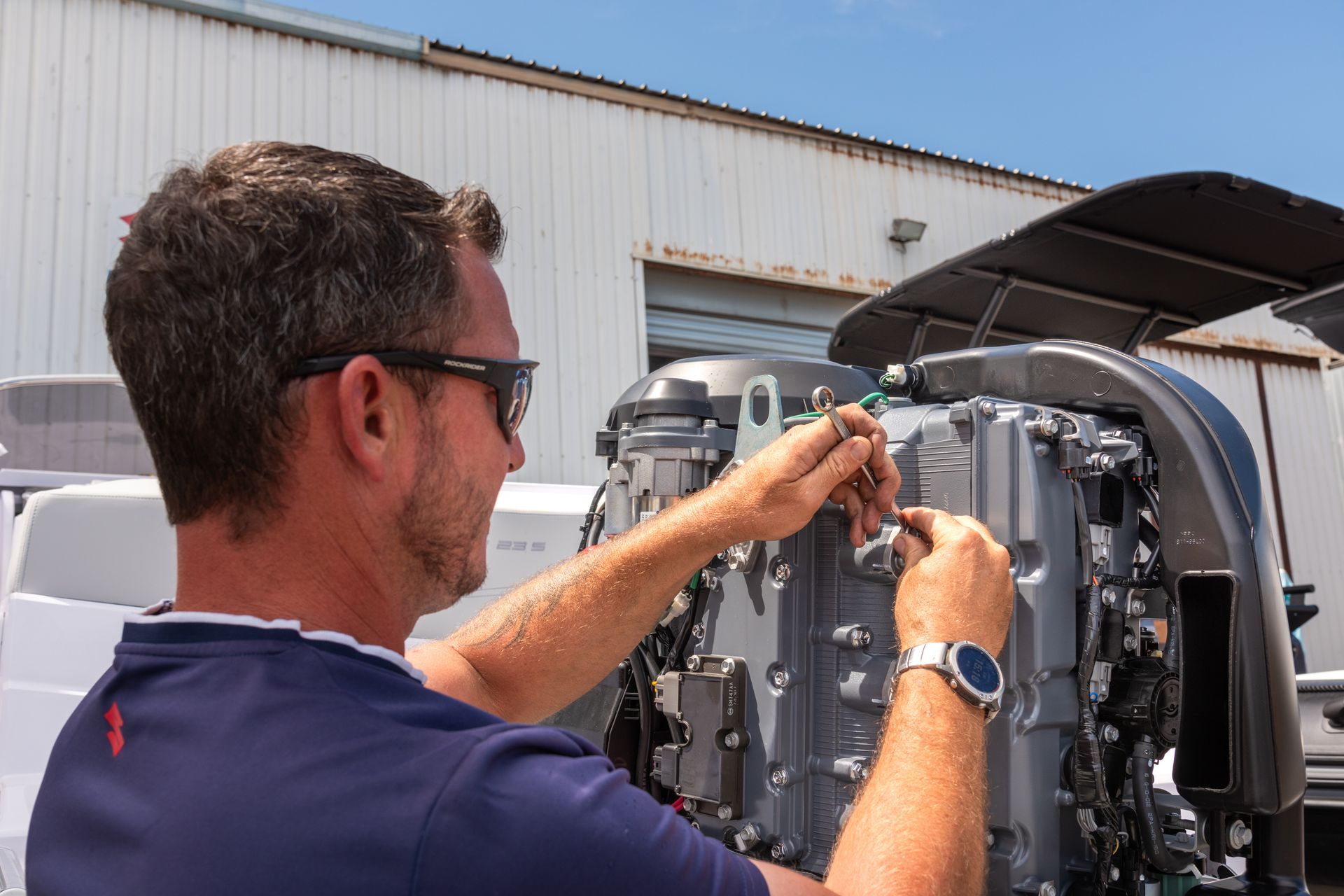 Homme qui entretien un moteur de bateau