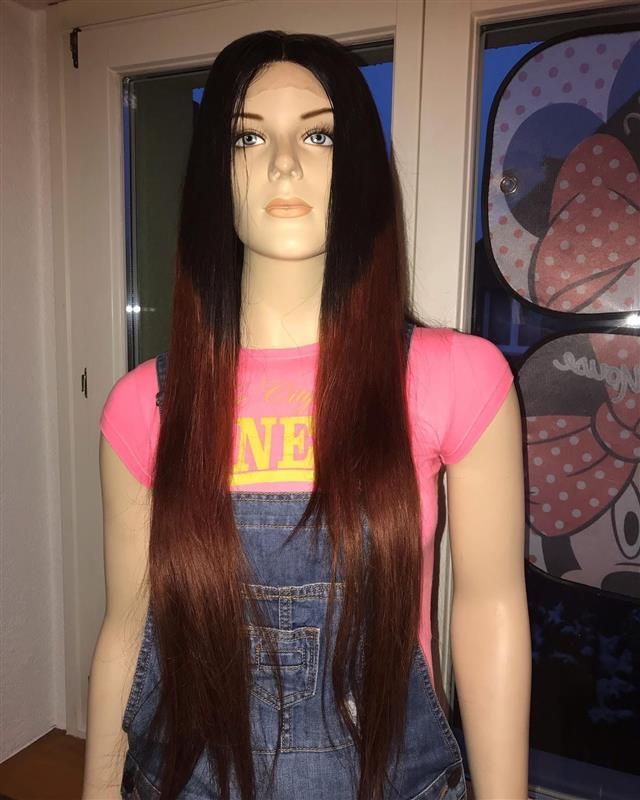 Schaufensterpuppe mit einer schwarz-roten Ombre-Perücke, einem rosa Hemd und einem Jeans-Overall.