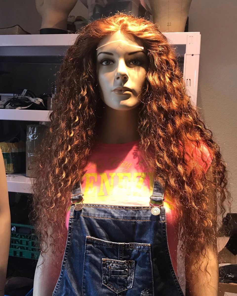 Schaufensterpuppe mit langen, lockigen roten Haaren, die einen Jeans-Overall und ein rosa Hemd trägt.