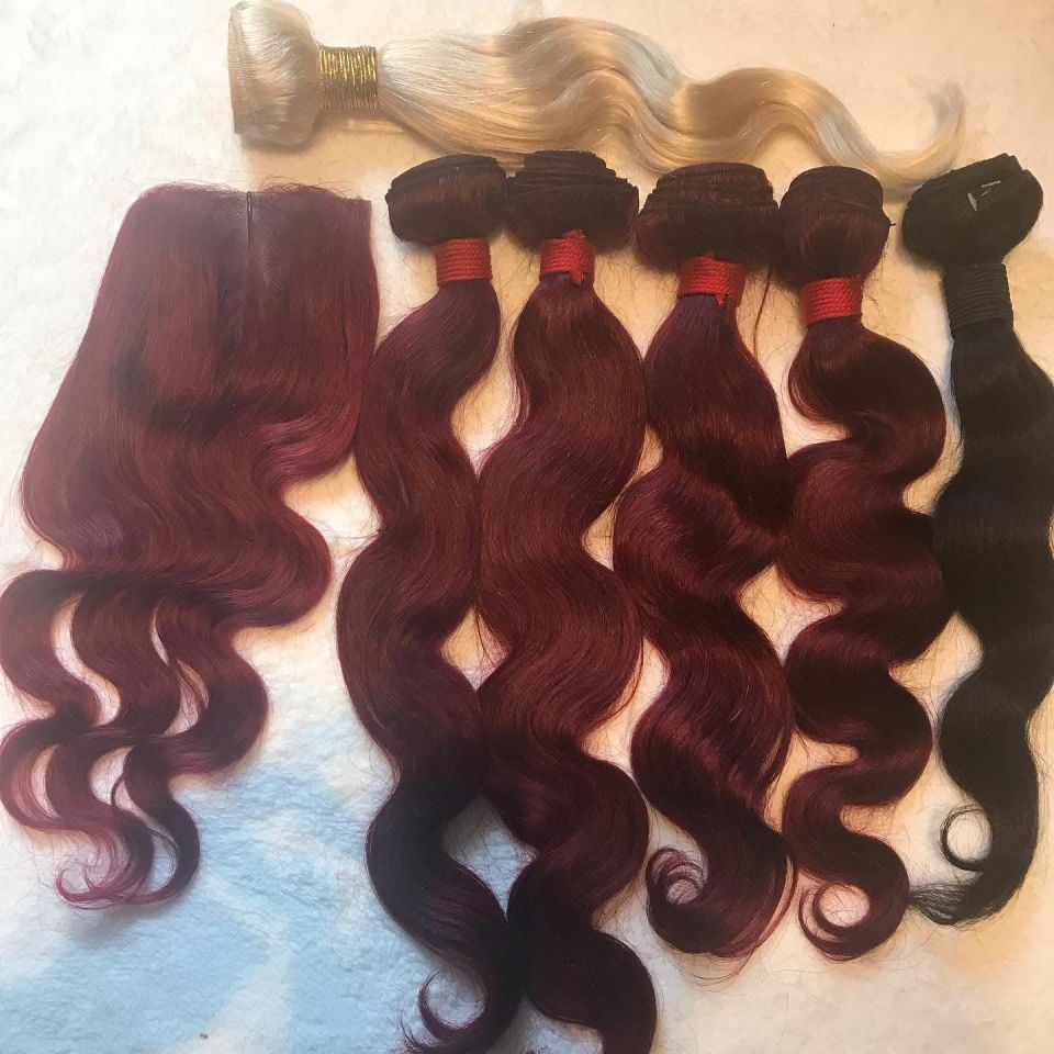 Haarverlängerungen: Rote, burgunderrote und schwarze gewellte Bündel mit Verschluss und ein blondes Bündel.