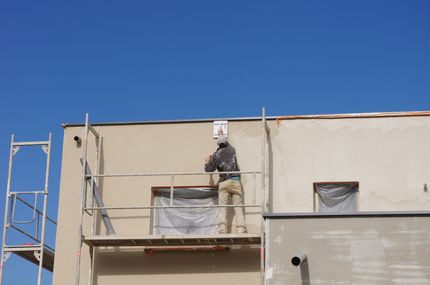 Un ouvrier fait un ravalement de façade