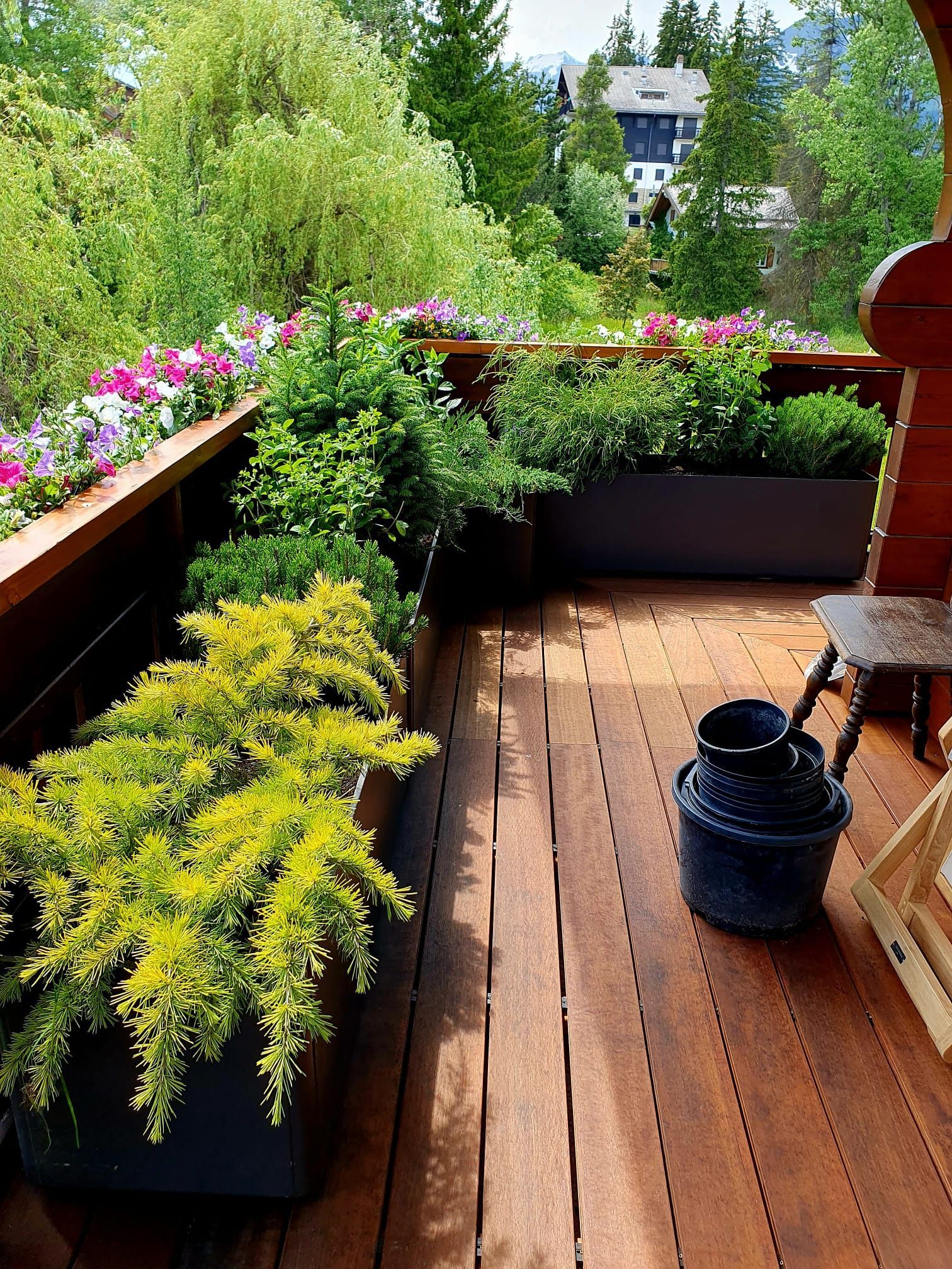 Une jardinière en bois avec des marches menant à un patio.