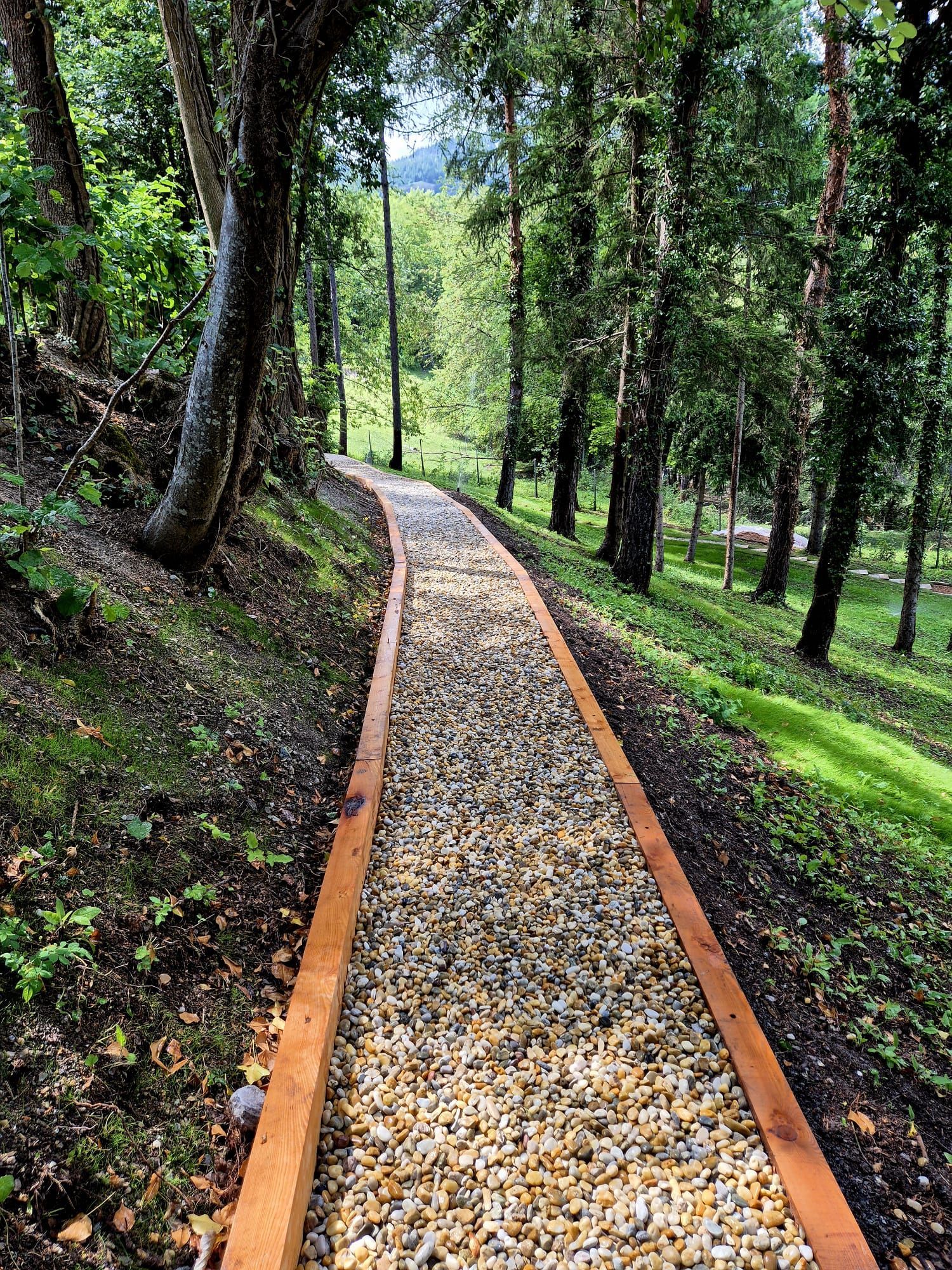 Un patio avec une allée en pierre et une clôture en bois en arrière-plan.