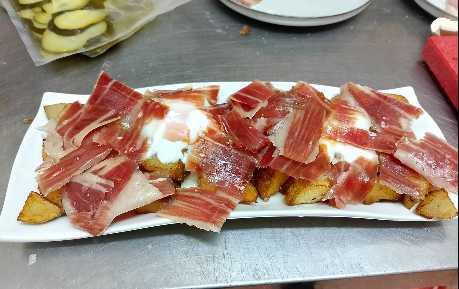 Un plato de comida con carne y patatas en una mesa.