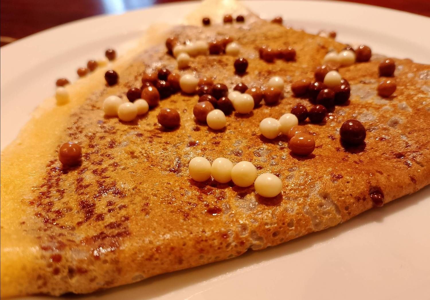 Una rebanada de pizza con chispas de chocolate en un plato blanco.