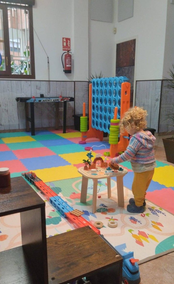Una niña está jugando con juguetes en una sala de juegos.