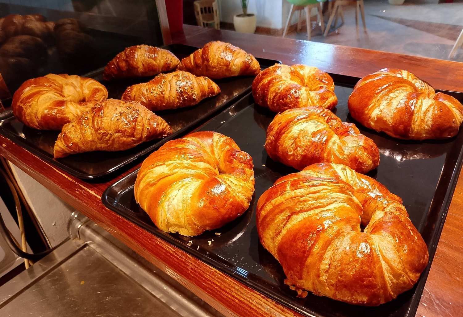 Un montón de croissants están colocados en una bandeja sobre una mesa.