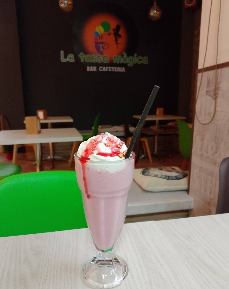Un batido rosa con crema batida y salsa de fresa