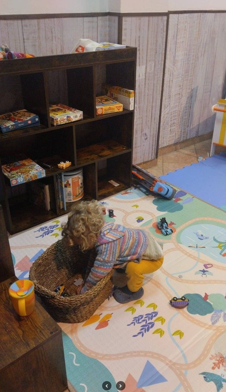 Un niño está jugando con un osito de peluche en una sala de juegos.