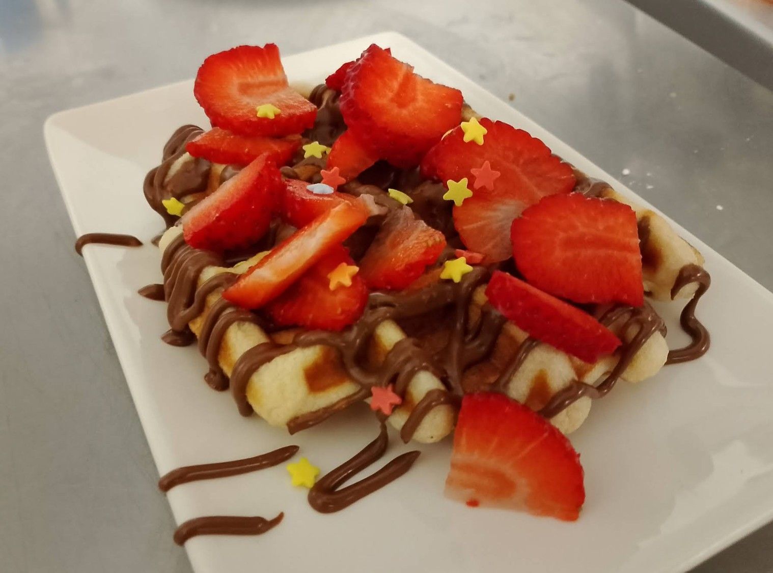 Un plato blanco cubierto con fresas y salsa de chocolate.