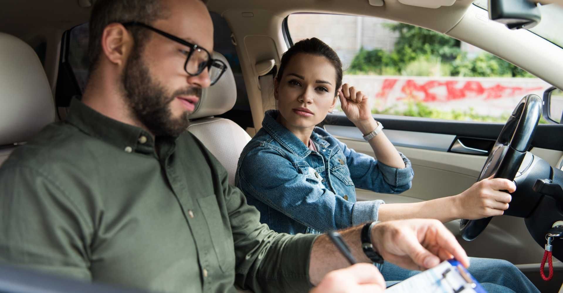 Un hombre le está enseñando a una mujer a conducir un coche.