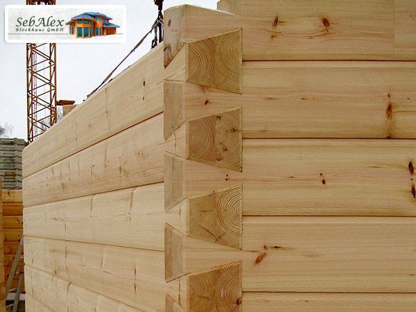 An einer Ecke ineinander verschachtelte Holzstämme zeigen die Baustelle einer Blockhütte.