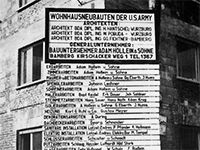 Ein Schwarzweißfoto eines Schildes an der Seite eines Gebäudes.