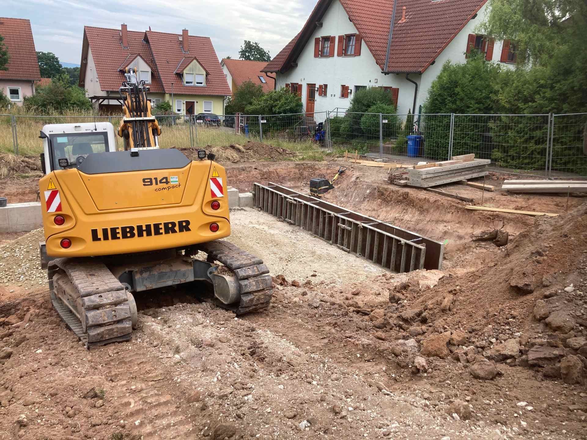 Ein gelbes Baufahrzeug von Liebherr fährt durch ein Feld.