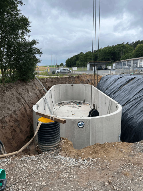 Auf einem Feld wird eine große Betonkonstruktion errichtet.