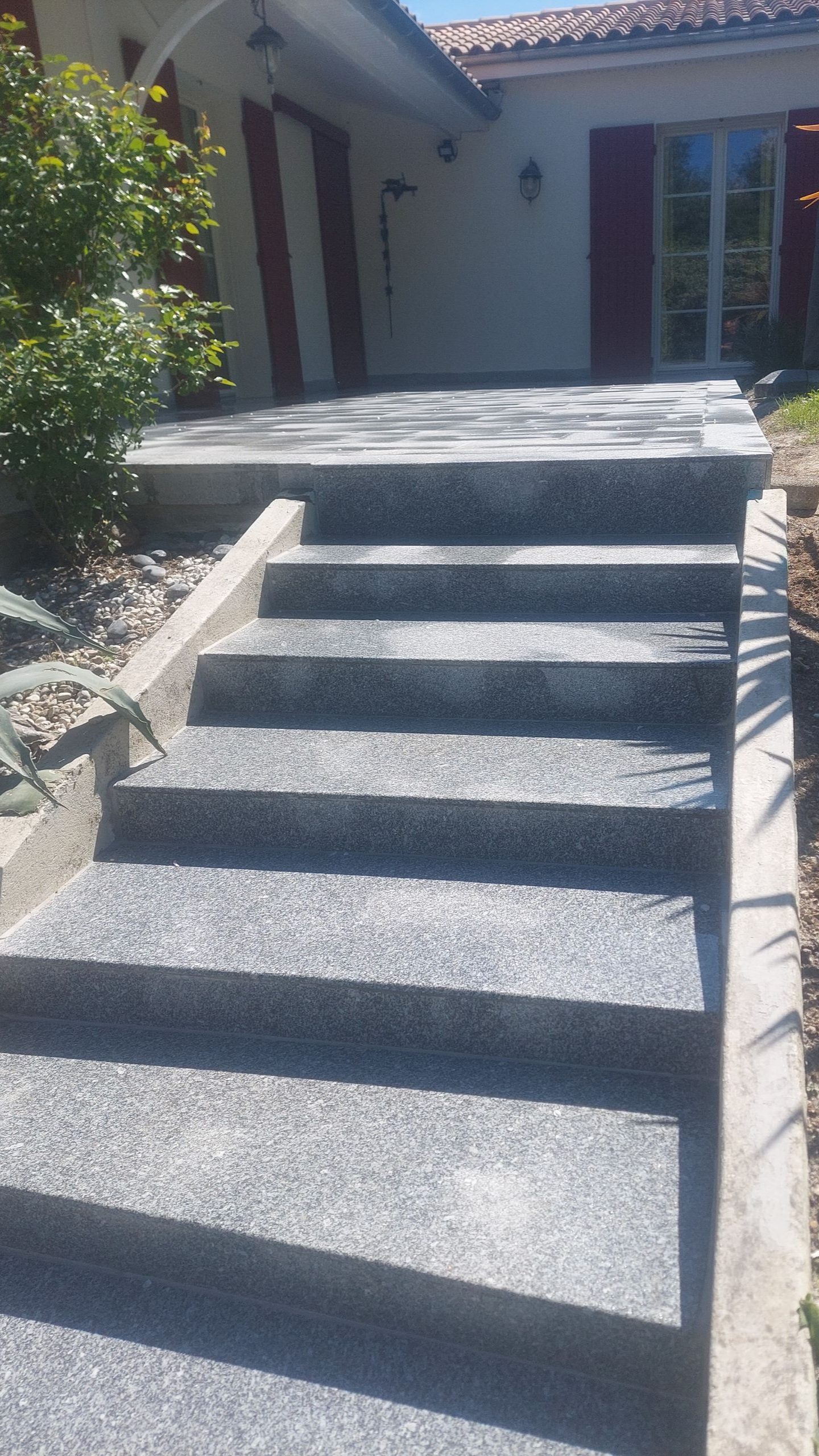 Escalier en granit qui amène vers l'entrée d'une maison
