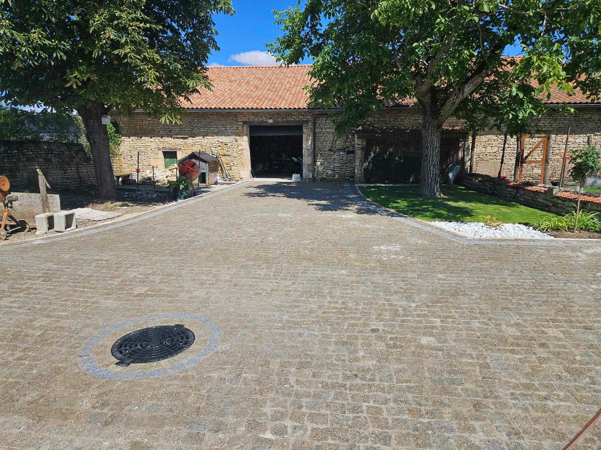 Accès des différents bâtiments d'une ferme en pavés de granit