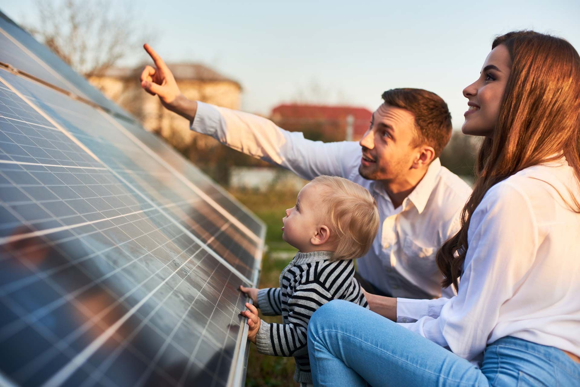 Une famille avec un enfant devant un panneau solaire