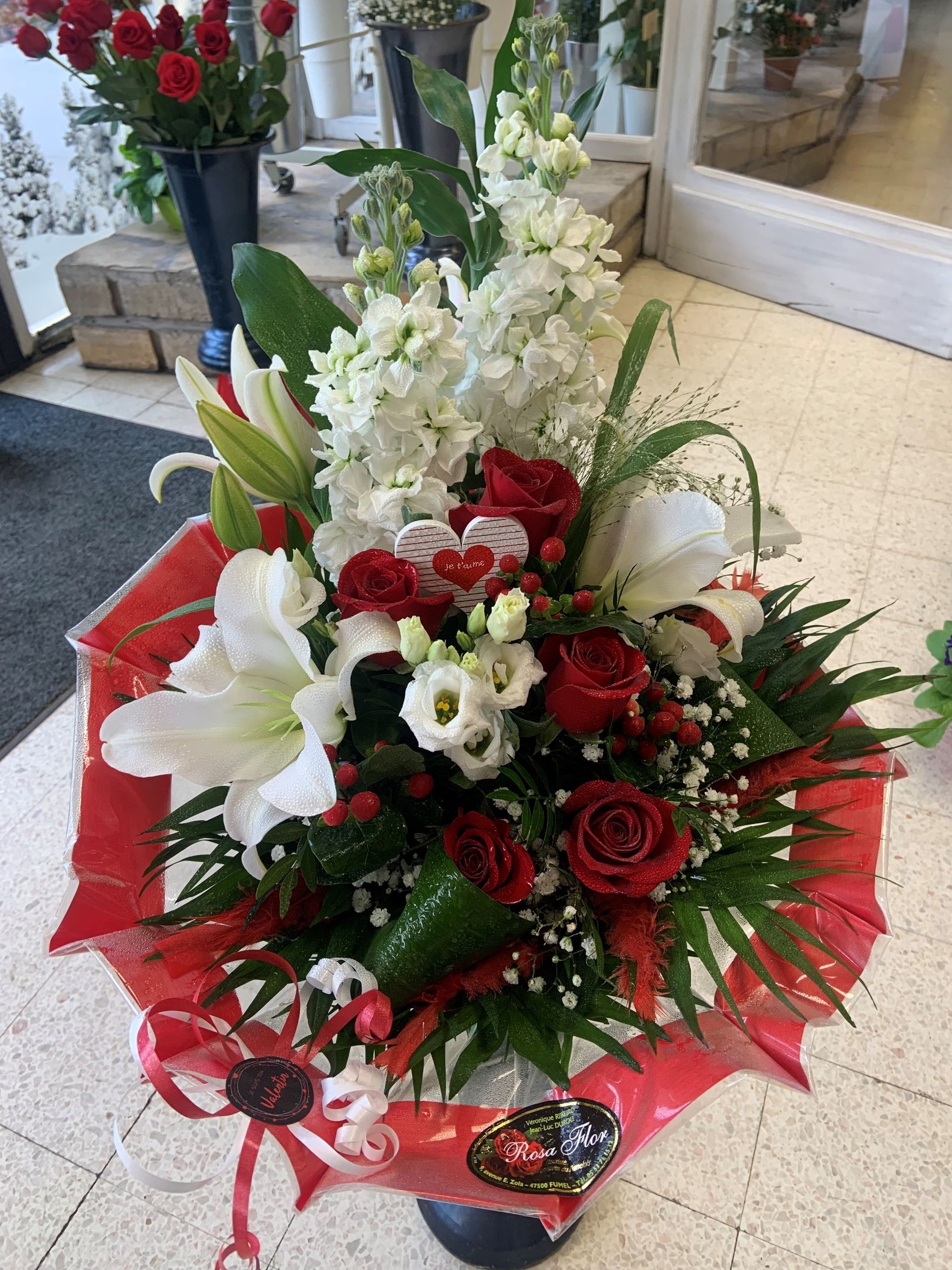 Bouquet avec des roses rouges et un papier rouge