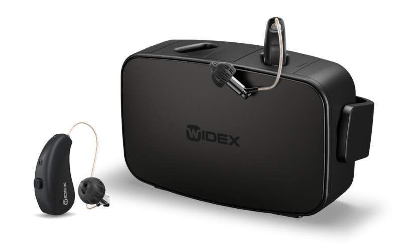 Un par de audífonos junto a un estuche que dice Widex.