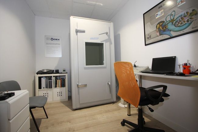 Una habitación con una silla y una computadora en un escritorio.